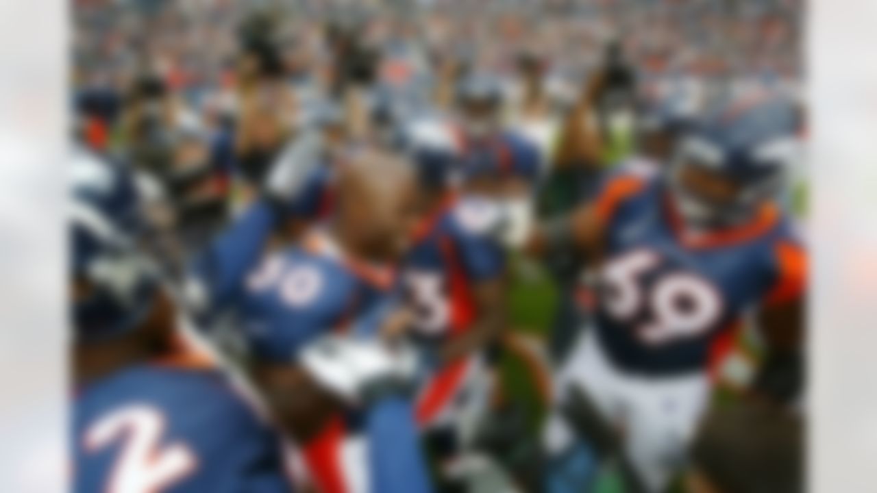 Denver Broncos running back Terrell Davis (30) exchanges high-fives with teammates as he is introduced prior to the start of Monday night's NFL exhibition game between the San Francisco 49ers and the Denver Broncos in Denver on August 19, 2002. (AP Photo/Jack Dempsey)