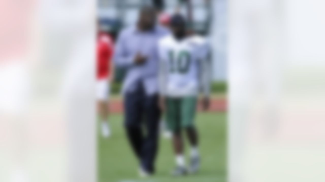 Former New York Jets receiver Keyshawn Johnson, left, talks with Jets wide receiver Santonio Holmes after practice on opening day of their NFL football training camp Friday, July 27, 2012 in Cortland, N.Y. (AP Photo/Bill Kostroun)