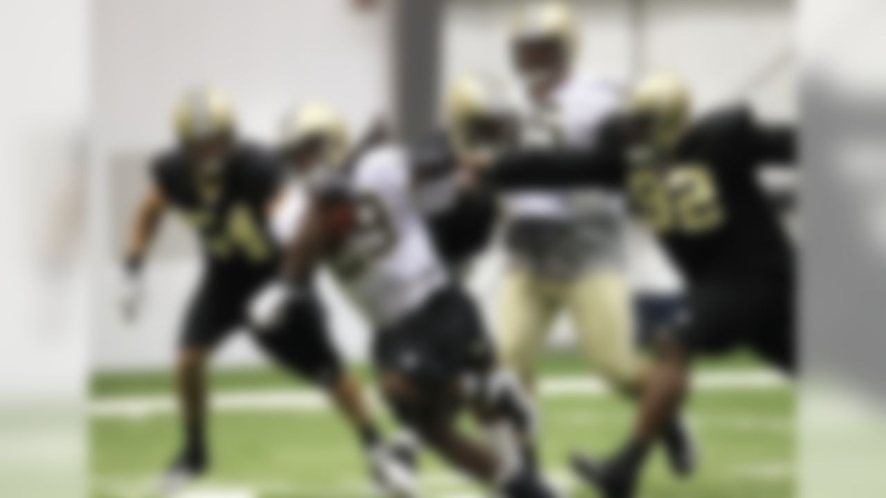 New Orleans Saints running back Chris Ivory (29) eludes defensive tackle Remi Ayodele (92) and linebacker Will Herring (54) during NFL football training camp at their training facility in Metairie, La., Thursday, July 26, 2012. (AP Photo/Gerald Herbert)