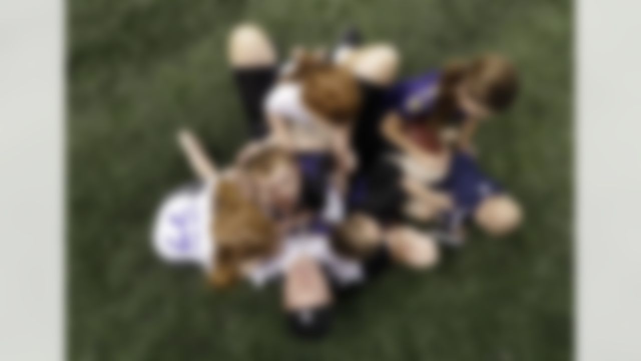 Baltimore Ravens center Matt Birk, bottom, plays with his children on the Mercedes-Benz Superdome field after an NFL Super Bowl XLVII walkthrough on Saturday, Feb. 2, 2013, in New Orleans. The Ravens face the San Francisco 49ers in Super Bowl XLVII on Sunday. (AP Photo/Patrick Semansky)