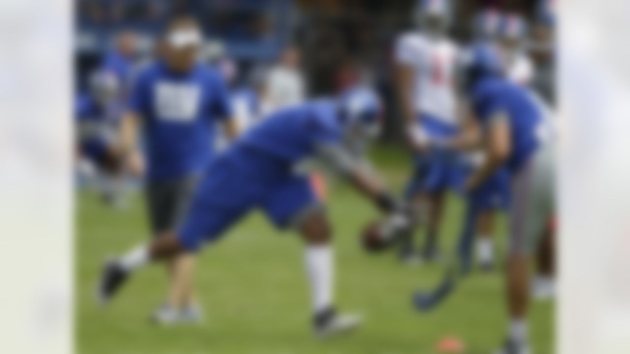 New York Giants kicker Lawrence Tynes, far right, holds a tethered ball as safety Chris Horton, center, performs a punt-blocking drill at NFL football training camp in Albany, N.Y., Sunday, July 29, 2012. (AP Photo/Kathy Willens)