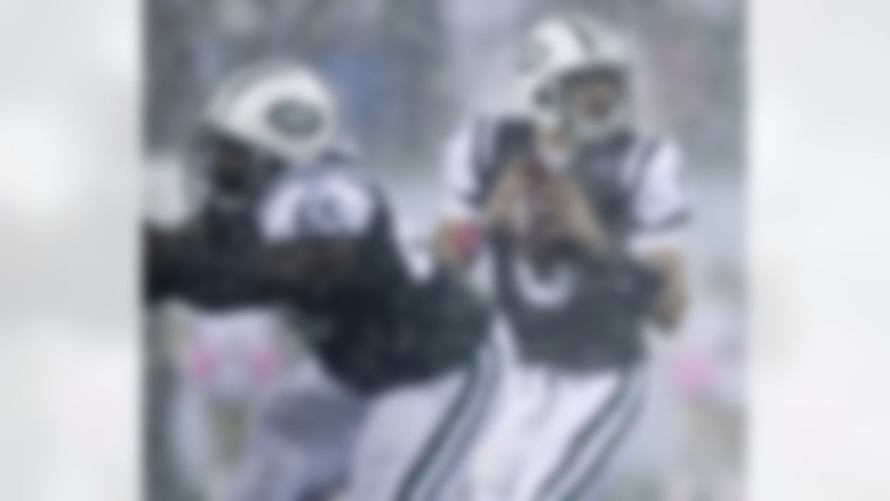 New York Jets quarterback Mark Sanchez looks to pass in a driving rain during the second quarter of an NFL football game against the Minnesota Vikings on Monday, Oct. 11, 2010, in East Rutherford, N.J. At left is Jets' Brandon Moore. (AP Photo/Seth Wenig)