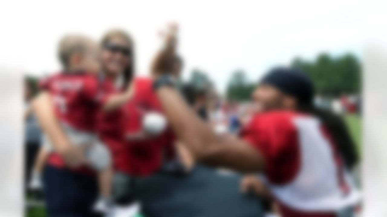 Arizona Cardinals' Larry Fitzgerald, right, gives a high-five to a young Cardinals fan as all players sign autographs prior to practice at NFL football training camp at Northern Arizona University on Saturday, July 28, 2012, in Flagstaff, Ariz. (AP Photo/Ross D. Franklin)