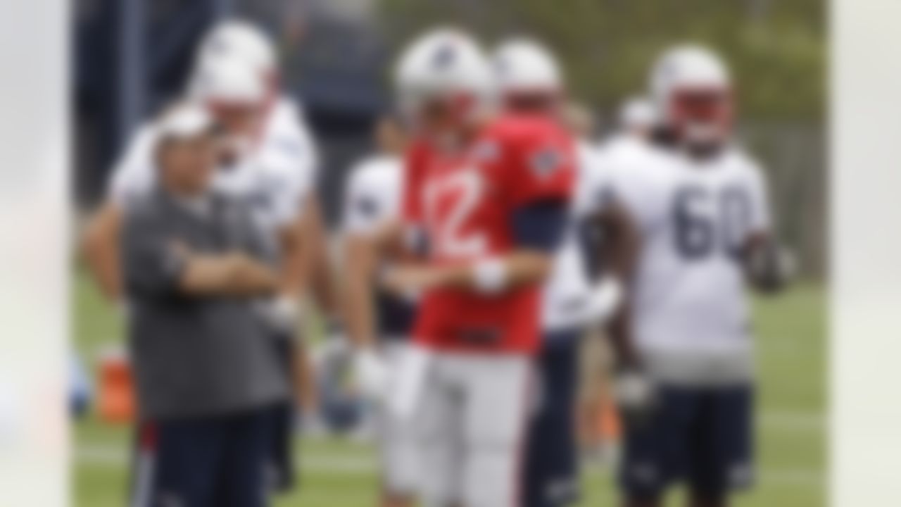 New England Patriots coach Bill Belichick looks over his practice field as quarterback Tom Brady (12) walks by during the first day of the NFL football team's training camp in Foxborough, Mass., Thursday, July 26, 2012. (AP Photo/Stephan Savoia)