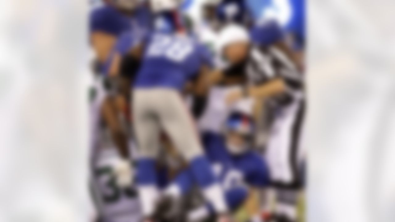 New York Giants' Eli Manning, bottom, gets up after being sacked during the second quarter of an NFL preseason football game against the New York Jets, Monday, Aug. 29, 2011, in East Rutherford, N.J. (AP Photo/Julio Cortez)