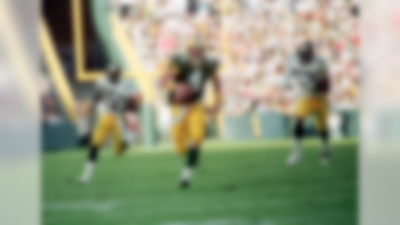 Green Bay Packers quarterback Brett Favre (4) runs for a first down while being chased by Pittsburgh Steelers linebacker Greg Lloyd (95) in the third quarter of their game in Green Bay, Wisconsin on Sept. 27, 1992. (AP Photo/Chris Corsmeier)
