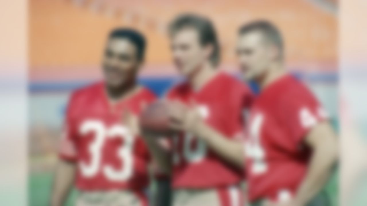 San Francisco 49ers' quarterback Joe Montana, center, holds a football as he poses for pictures with running back Roger Craig, left, and fullback Tom Rathman during Super Bowl Media Day, Jan. 17, 1989, in Miami. (AP Photo/Al Behrman)
