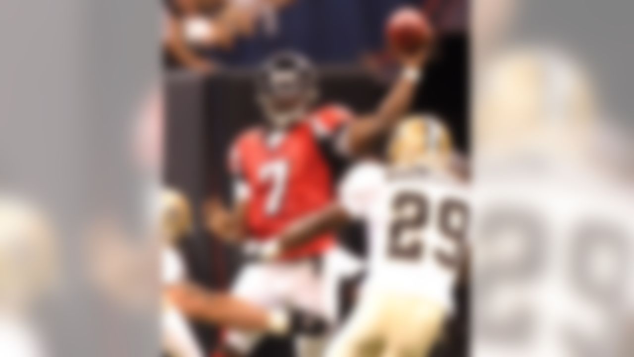 Atlanta Falcons quarterback Michael Vick (7) passes over the defense of New Orleans Saints' Josh Bullocks (29) in the first quarter of their NFL football game at the newly re-opened Louisiana Superdome in New Orleans on Monday, Sept. 25, 2006. (AP Photo/Dave Martin)
