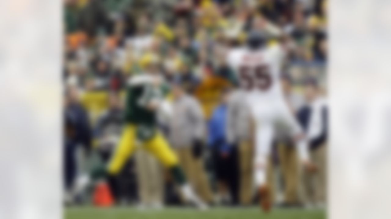 Green Bay Packers quarterback Aaron Rodgers (12) throws a pass over Chicago Bears linebacker Lance Briggs (55) during the second half of an NFL football game Sunday, Nov. 16, 2008, in Green Bay, Wis. The Packers won 37-3. (AP Photo/Morry Gash)