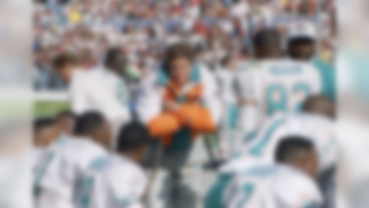 Dan Marino of the Miami Dolphins, center, stands on crutches while conversing with teammates on the sidelines of their game with the Cleveland Browns, Oct. 10, 1993, Cleveland, Ohio. Marino was injured in the first half and had to be taken out. (AP Photo/Jeff Glidden)