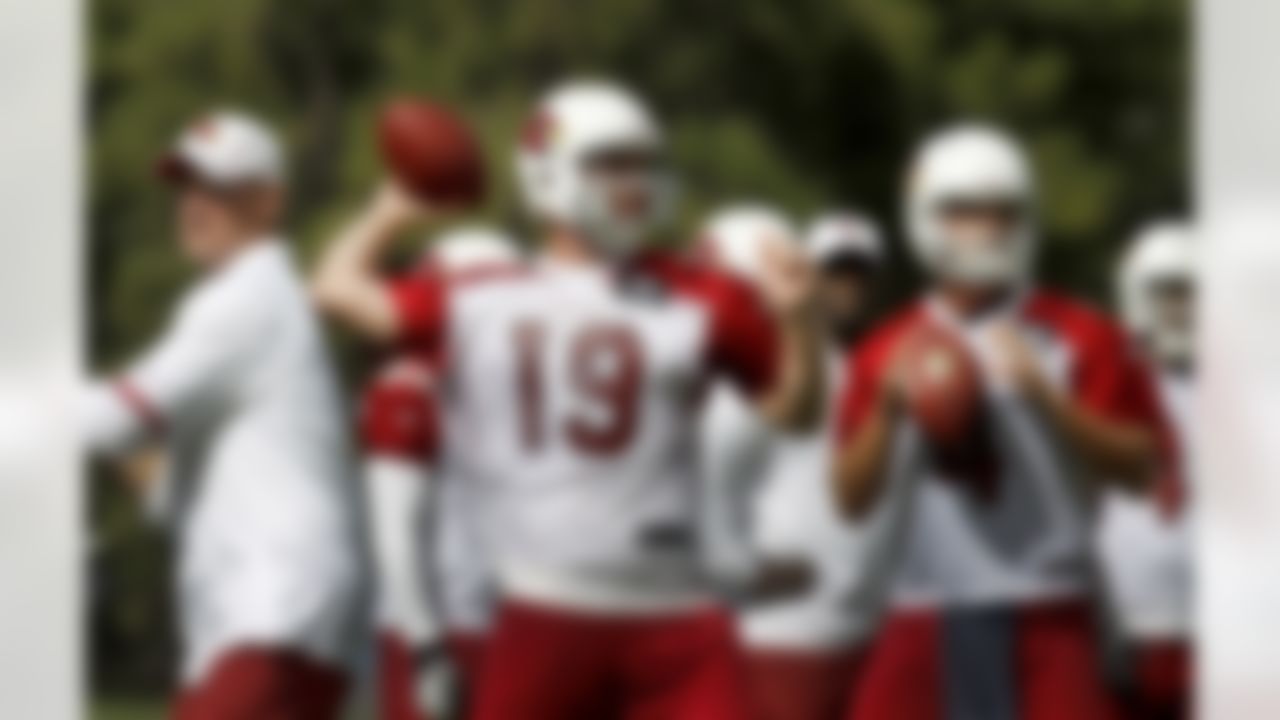 Arizona Cardinals' John Skelton (19) joins Kevin Kolb, right, as head coach Ken Whisenhunt, left, looks on at other action during the first day of NFL training camp football practice at Northern Arizona University, Wednesday, July 25, 2012, in Flagstaff, Ariz.(AP Photo/Ross D. Franklin)