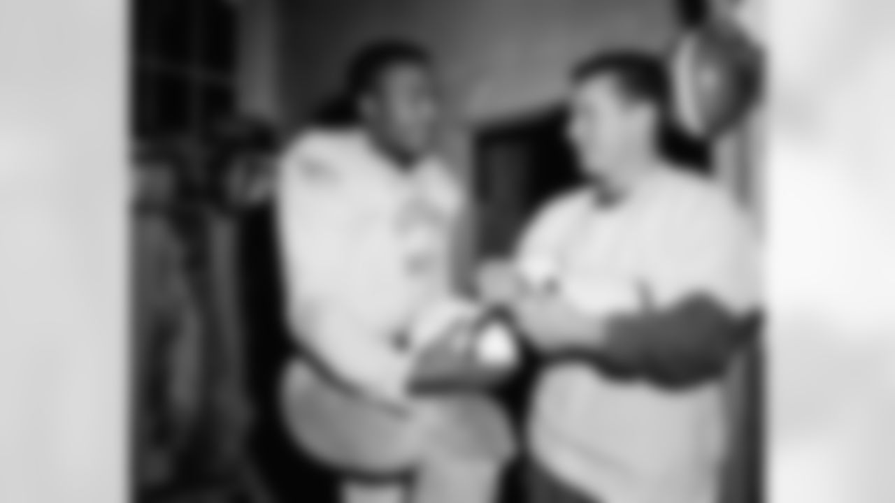 Fullback Jim Brown (left) and quarterback Tommy O'Connell, shown autographing footballs, are set for National Football League championship game with the Detroit Lions at Briggs Stadium in Detroit on Sunday, Dec. 27, 1957. O'Connell, the league's leading passer, and Brown, the NFL's leading ground gainer, are two big reasons why the Cleveland Browns are on top of the eastern division. They are also two good reasons why the Lions should be wary of the power-packed Clevelanders next Sunday. (Associated Press)