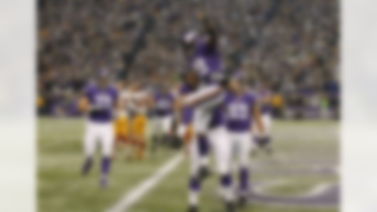 Minnesota Vikings running back Adrian Peterson, center, celebrates with teammates after scoring on a 1-yard touchdown run during the second half of an NFL football game against the Washington Redskins, Thursday, Nov. 7, 2013, in Minneapolis. (AP Photo/Ann Heisenfelt)