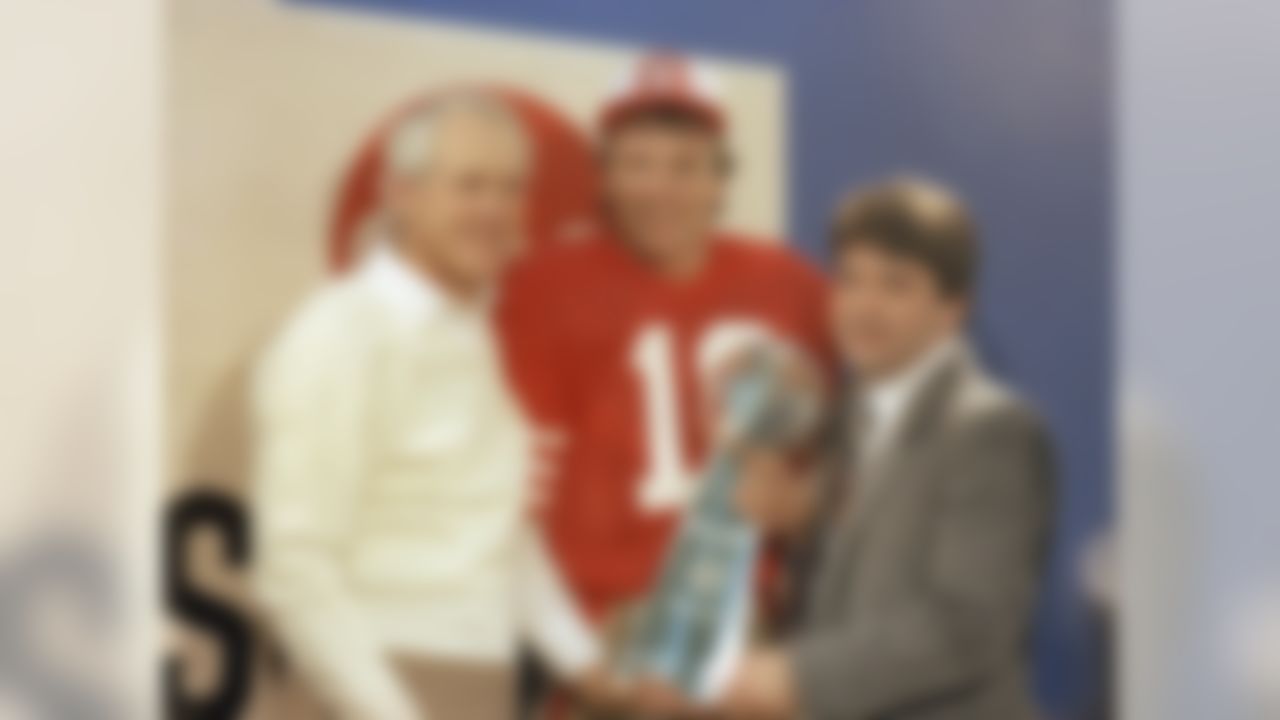 San Francisco 49ers' quarterback Joe Montana (16) holds the Lombardi Super Bowl trophy with coach Bill Walsh and 49ers' owner Edward DeBartolo, Jr. following the Super Bowl XIX at Stanford Stadium in Stanford, CA on January 20, 1985. (Associated Press)