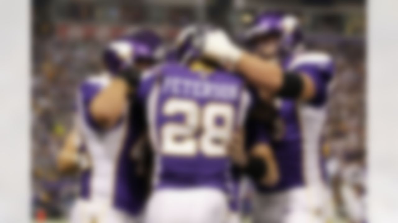 Minnesota Vikings running back Adrian Peterson (28) is congratulated by teammates after scoring a touchdown during the second half of an NFL football game Sunday, Dec. 30, 2012, in Minneapolis. (AP Photo/Genevieve Ross)