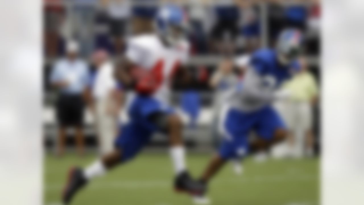 New York Giants running back Ahmad Bradshaw (44) carries the ball with cornerback Terrell Thomas (24) chasing alongside on a running play during a practice at NFL football training camp in Albany, N.Y., Saturday, July 28, 2012. (AP Photo/Kathy Willens)