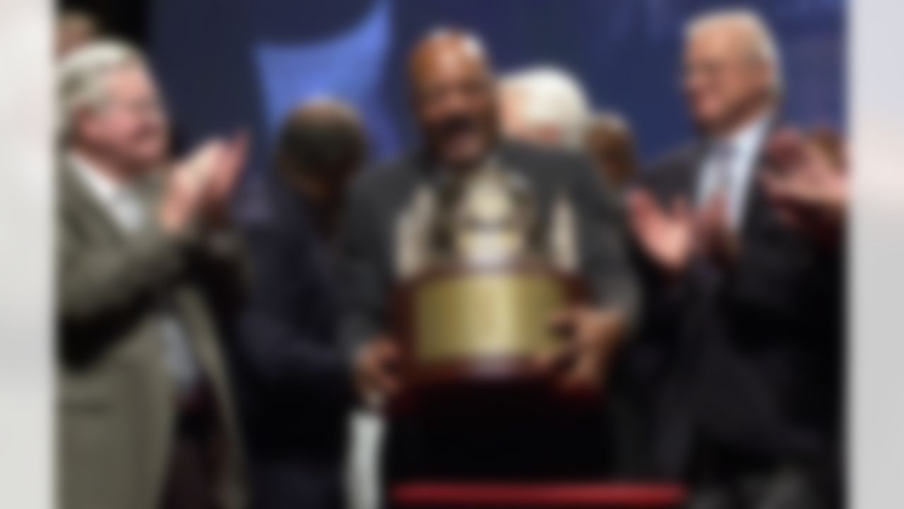Jim Brown, center, picks up a trophy presented by NFL Commisioner Paul Tagliabue, to the members of Cleveland Browns 1964 Championship Team, at Severance Hall in Cleveland, Friday, Sept. 10, 2004. At left is Bernie Parish, and at right Paul Wiggin. The original trophy presented to the team after their 1964 victory over the Baltimore Colts is in the possession of the Green Bay Packers, who were the 1965 Championship Team. (AP Photo/Jamie-Andrea Yanak)