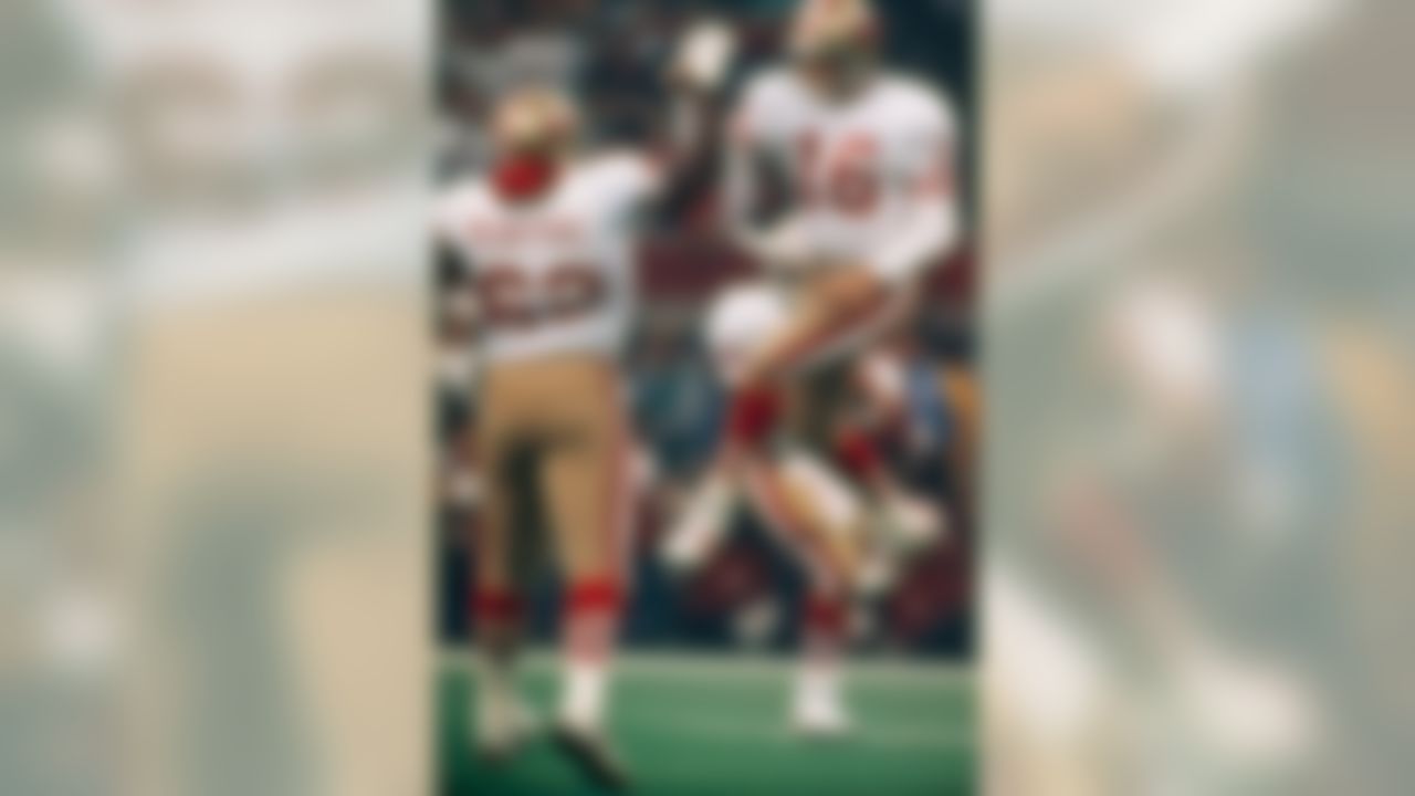 San Francisco 49ers quarterback Joe Montana (16) is walking on air after a third quarter touchdown in Super Bowl XXIV, Sunday, Jan. 28, 1990 in New Orleans Montana, who was awarded the MVP trophy for his record-setting performance is congratulated by teammate Guy McIntyre. (AP Photo/Mark Duncan)