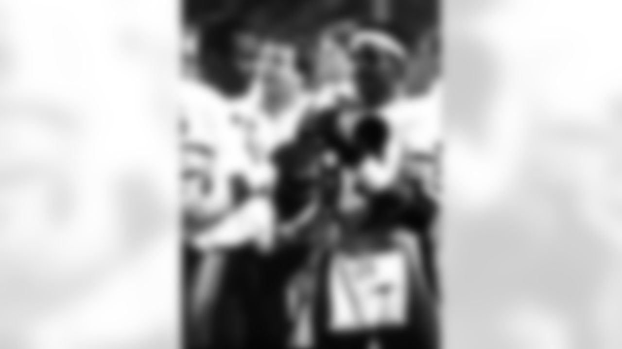 Hall of Fame running back Walter Payton (34) of the Chicago Bears shows running back Neal Anderson the photographic ropes in the latter stages of the Bears 10-3 preseason victory over the Miami Dolphins on August 16, 1987 at Joe Robbie Stadium in Miami, Florida. (Perry McIntyre/NFL)