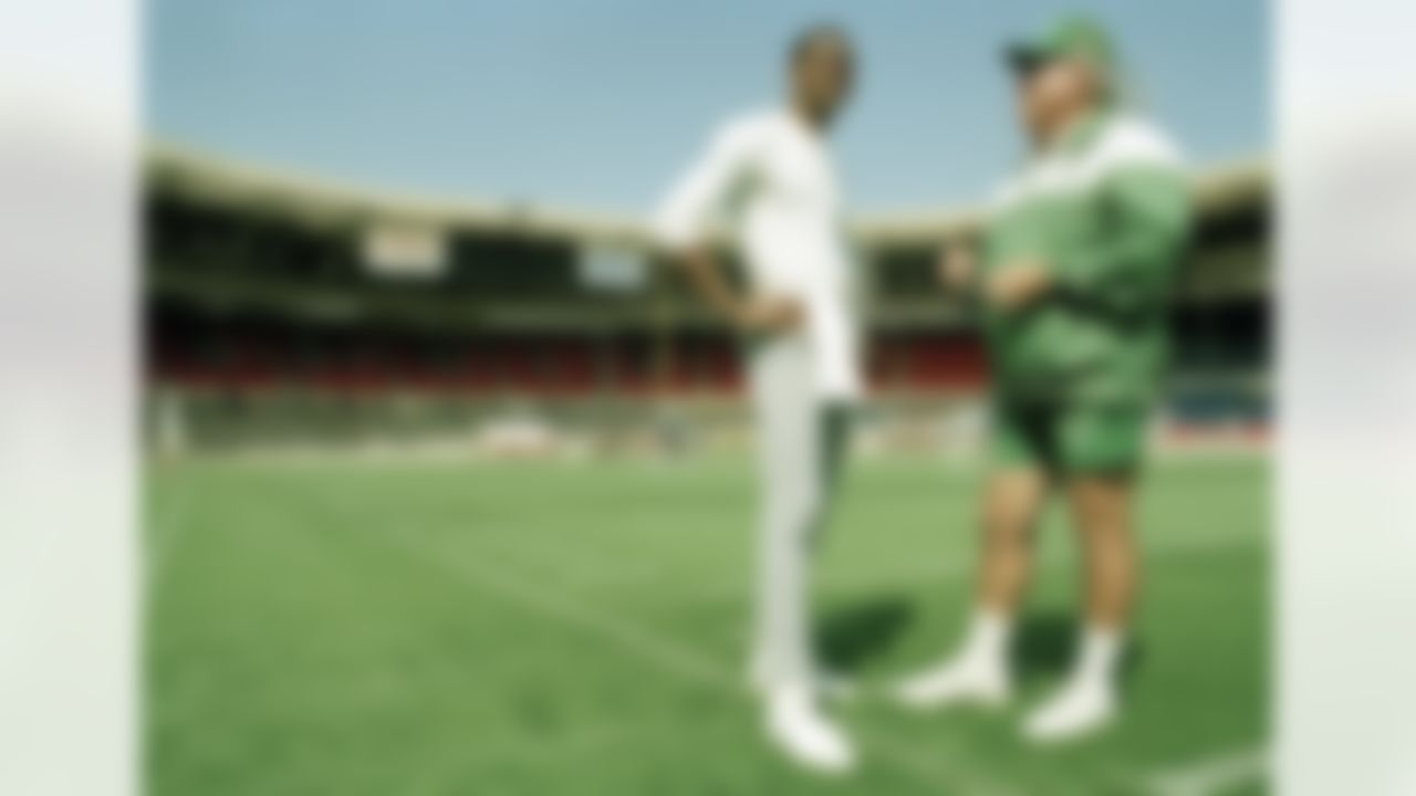 Randall Cunningham, quarterback for the Philadelphia Eagles talks with head coach Buddy Ryan during a light training session, Aug. 5, 1989, at London's Wembley Stadium where they will take on the Cleveland Browns for the 1989 American Bowl. (AP Photo/Gillian Allen)