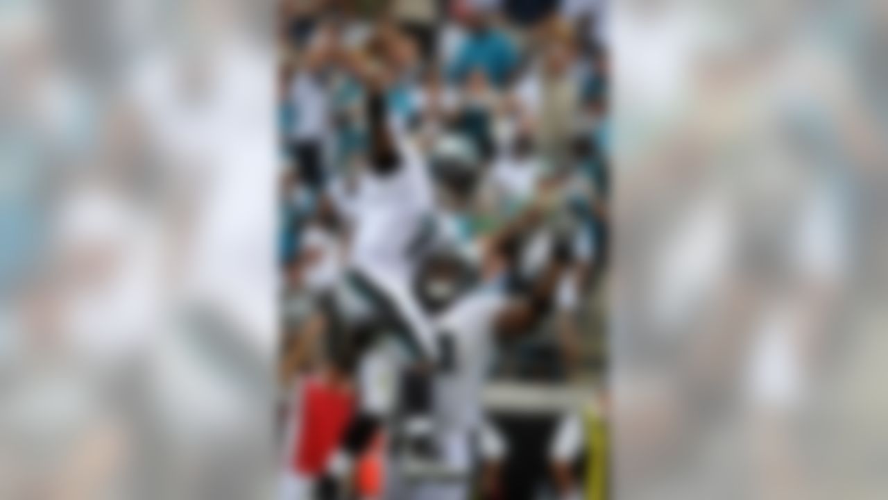 Philadelphia Eagles quarterback Michael Vick (7) is lifted in the air by teammate Philadelphia Eagles offensive tackle Jason Peters (71) after throwing a touchdown pass in the second quarter during an NFL football game against the Jacksonville Jaguars in Jacksonville, Fla., Sunday, Sept. 26, 2010. (AP Photo/Stephen Morton)