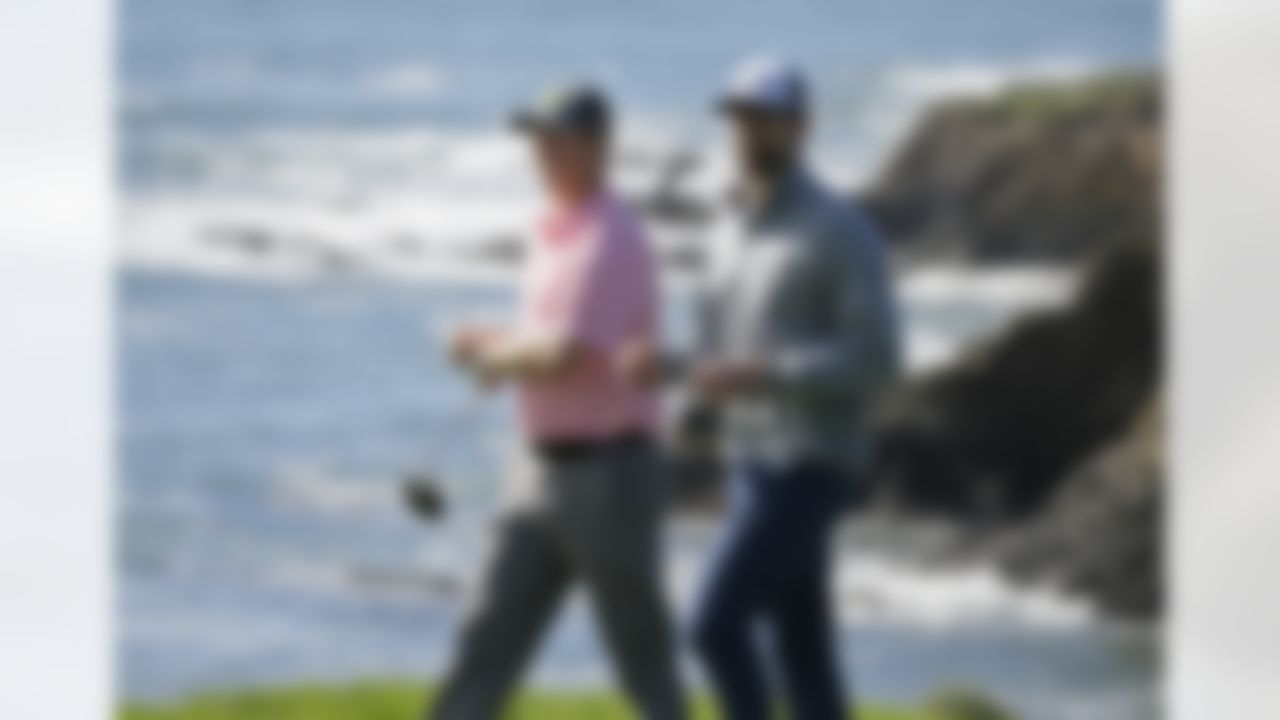 San Francisco Giants pitcher Matt Cain, left, and Green Bay Packers quarterback Aaron Rodgers, right, walk down the ninth fairway of the Pebble Beach Golf Links during the third round of the AT&T Pebble Beach National Pro-Am golf tournament Saturday, Feb. 11, 2017, in Pebble Beach, Calif. (AP Photo/Eric Risberg)