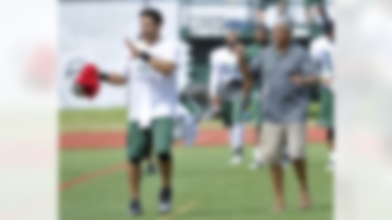 New York Jets quarterback Mark Sanchez, left, walks off the practice field with his father, Nick, on opening day of their NFL training camp Friday, July 27, 2012 in Cortland, N.Y. (AP Photo/Bill Kostroun)