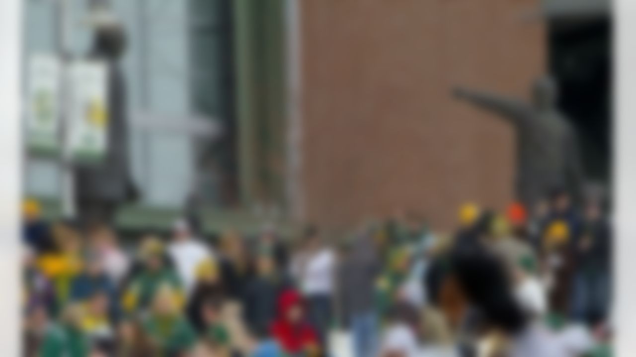 Green Bay Packers fan stand near statues of Vince Lombardi, left, and Curly Lambeau as they await the NFL football team's return Monday, Feb. 7, 2011, to Lambeau Field in Green Bay, Wis., the day after the Packers defeated the Pittsburgh Steelers 31-25 in Super Bowl XLV. (AP Photo/Mike Roemer)