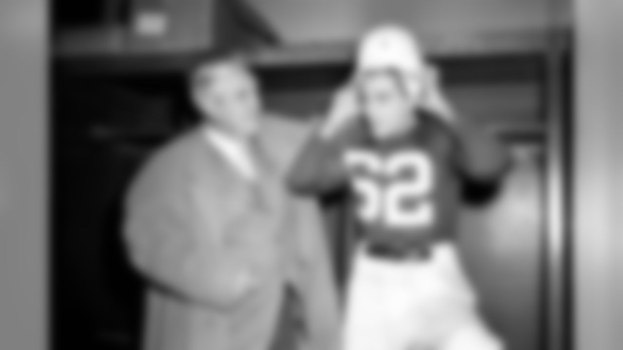 Charley Trippi, right, 24-year-old All-America Halfback from Georgia, tries on a Chicago Cardinal uniform at Comiskey Park, Chicago, Jan 17, 1947 after signing a four-season $100,000 contract with the National Football League. Cardinal Coach Jimmy Conzelman looks on. (Associated Press)