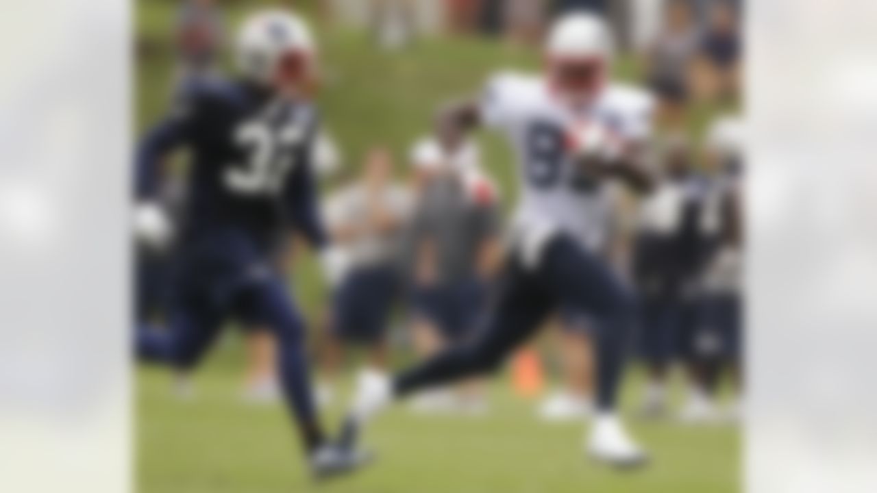 New England Patriots wide receiver Brandon Lloyd (85) is chased by cornerback Devin McCourty (32) after catching a pass during practice on the second day of NFL football training camp in Foxborough, Mass., Friday, July 27, 2012. (AP Photo/Stephan Savoia)