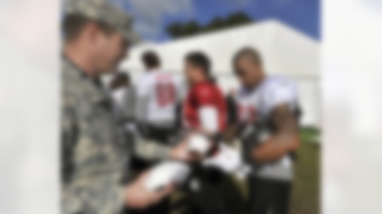 Tampa Bay Buccaneers tight end Kellen Winslow signs a football for soldiers stationed at the US Embassy in London after practice
at Pennyhills Park in Surrey, England on October 20, 2011. (Sean Ryan/NFL)