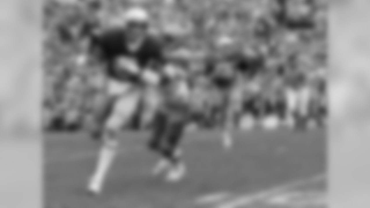Notre Dame's Joe Montana tries to brush off Georgia Techs' Reggie Wilkes on a 6-yard gain in the first quarter of an NCAA college football game at South Bend, Ind. (Associated Press)