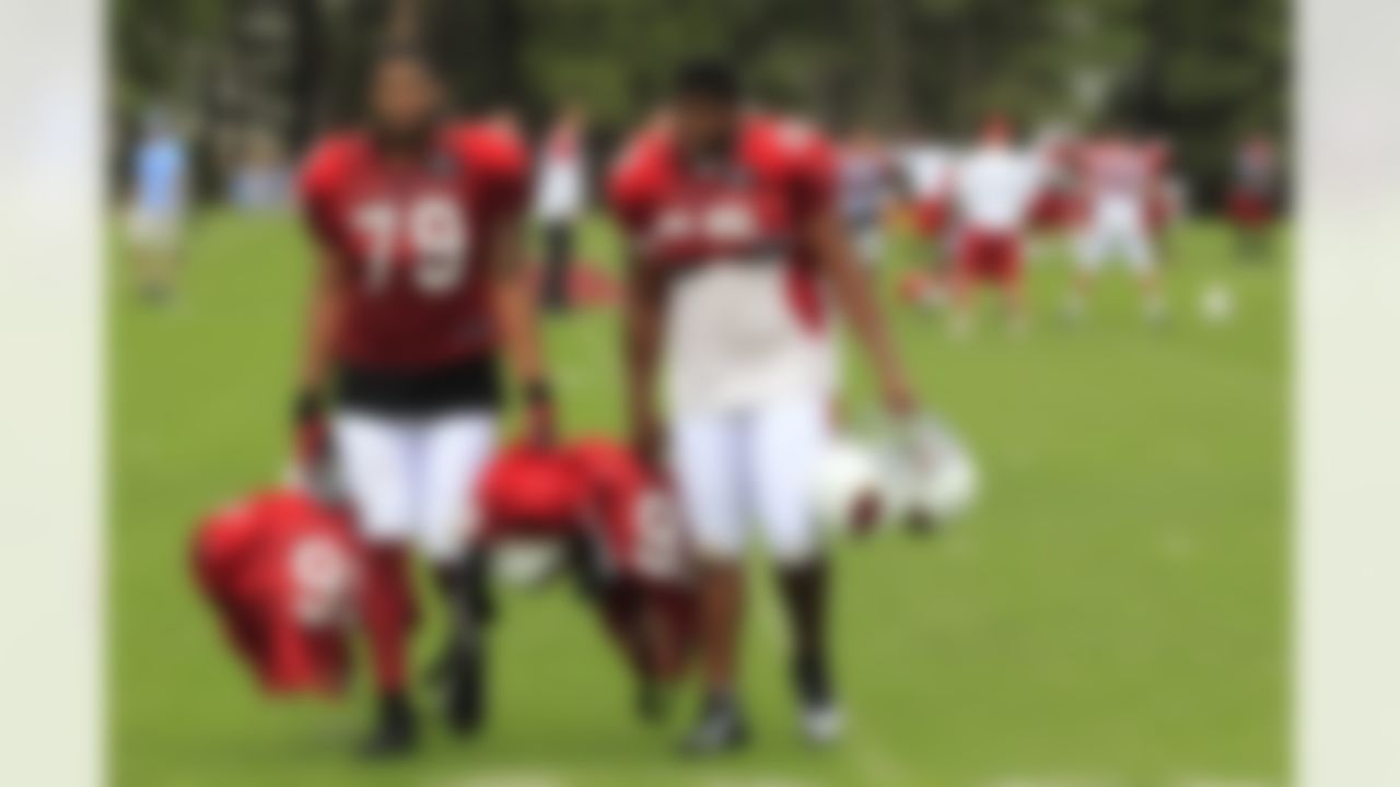 Arizona Cardinals' David Carter (79) and Ricky Lumpkin carry teammates' gear off the field after NFL football training camp at Northern Arizona University, Thursday, July 26, 2012, in Flagstaff, Ariz. (AP Photo/Ross D. Franklin)