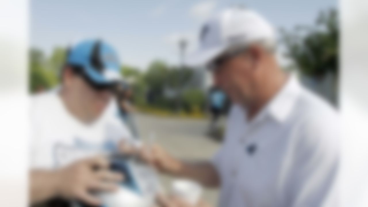 Carolina Panthers' coach John Fox, right, signs a helmet for a fan before rookie football mini-camp on Saturday, May 1, 2010 in Charlotte, N.C. (AP Photo/Rick Havner)