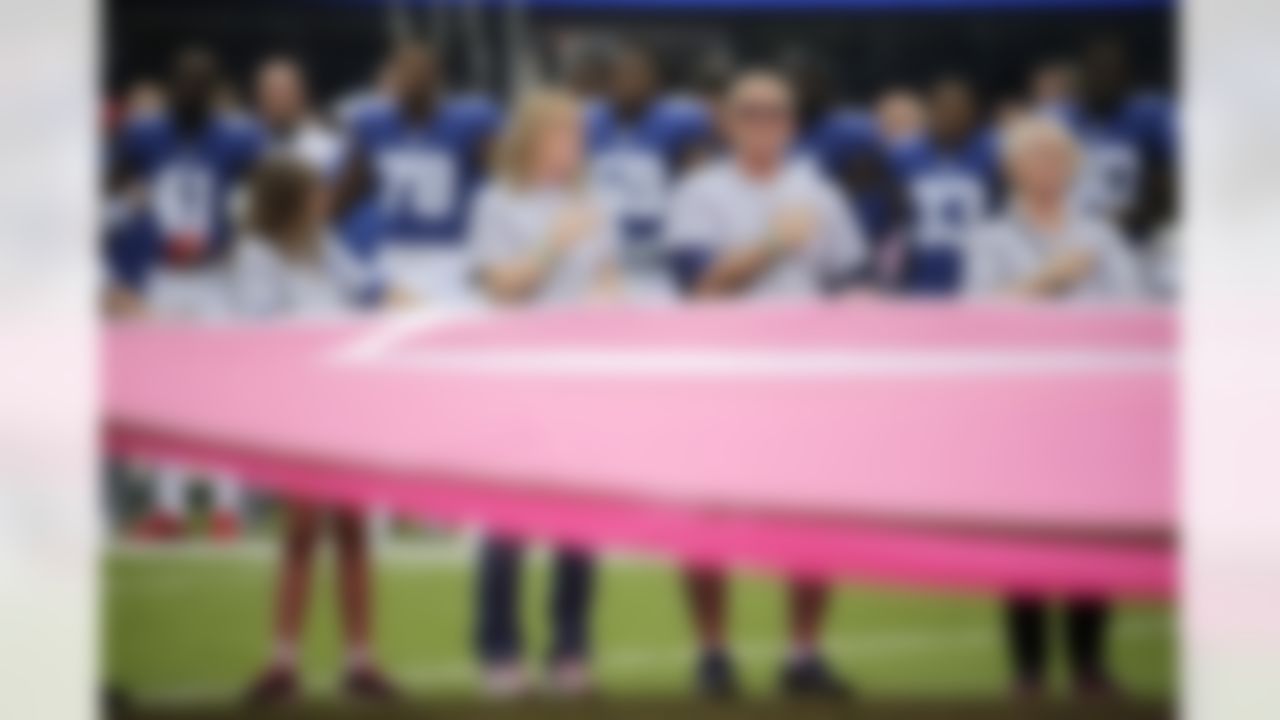 Cancer survivors hold a large pink ribbon on the field during the national anthem prior to an NFL football game between the New York Giants and the Los Angeles Chargers, Sunday, Oct. 8, 2017, in East Rutherford, N.J.