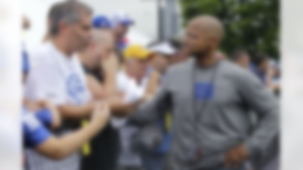 New York Giants general manager Jerry Reese, right, talks to a fan at the NFL football team's training camp in Albany, N.Y., Saturday, July 28, 2012. Reese isn't making any guarantees about either winning another Super Bowl or starting the next NFL dynasty. Reese likes the Giants' roster that he kept mostly intact in the off-season and he believes Tom Coughlin's team has as good a chance as anybody at getting to New Orleans for another shot at the Super Bowl. (AP Photo/Kathy Willens)
