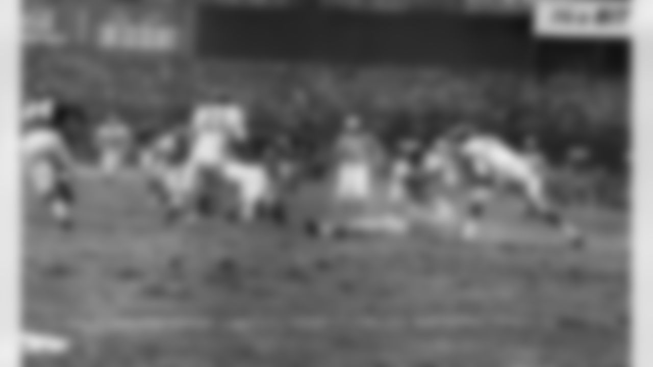 New York Giants' Frank Gifford lies on field as play continues after he was knocked unconsoious by Philadelphia's Chuck Bednarik (60) as Gifford was carrying the ball. Play came in fourth quarter of game at New York's Yankee Stadium, November 21, 1960. Eagle's Chuck Weber is diving on Ball. (Associated Press)