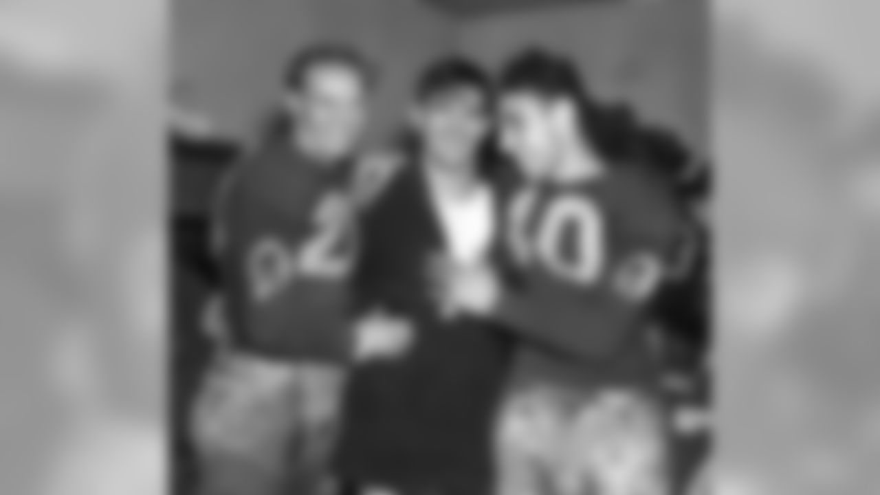 Washington Redskins quarterback Sammy Baugh, center, celebrates with teammates Cliff Battles, left, and Wayne Millner in the locker room after defeating the Chicago Bears in the National Football League Championship game in Chicago, Ill., on Dec. 12, 1937. Baugh completed 17 out of 34 passes, Millner scored two of the team's four touchdowns, and Battles scored one, to give their team a 28-21 victory. (Associated Press)