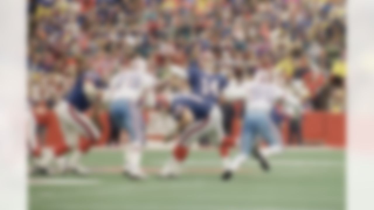 Buffalo Bills quarterback Frank Reich looks to throw during third quarter action against the Houston Oilers on Sunday, Jan. 3, 1991 at Rich Stadium in Orchard Park. Bills tackle Wil Wolford (69) blocks Oilers defensive end Ray Childress (79) as Sean Jones (96) closes in. Reich led the Bills to a 41-38 overtime victory. (AP Photo/Harry Scull, Jr.)