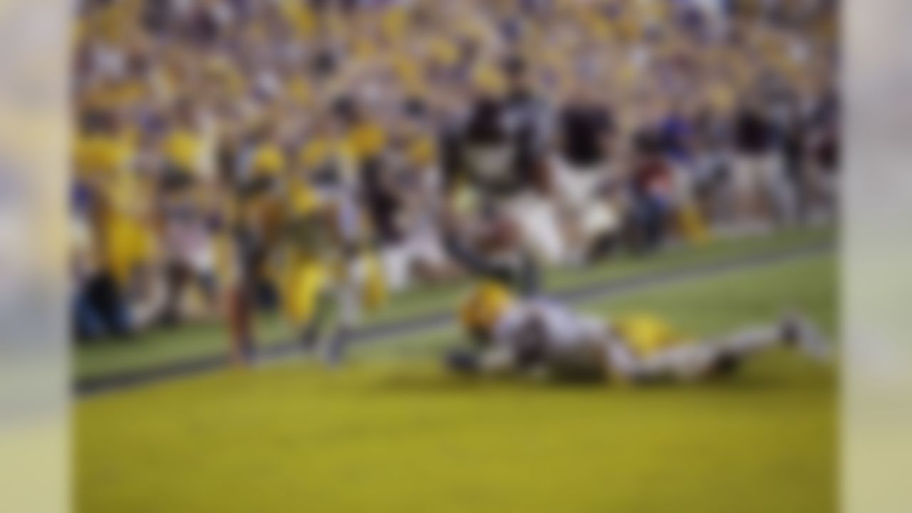 Mississippi State quarterback Dak Prescott (15) dives into the end zone over LSU cornerback Dwayne Thomas (13) and safety Ronald Martin (26) on a 56 yard touchdown carry in the second half of an NCAA college football game in Baton Rouge, La., Saturday, Sept. 20, 2014. (AP Photo/Gerald Herbert)