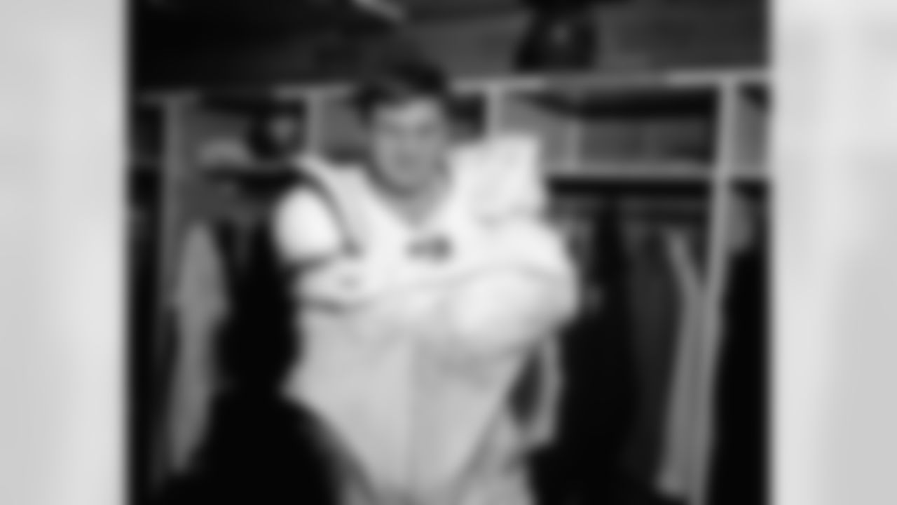Chuck Bednarik of the Philadelphia Eagles removes his uniform in St. Louis, Dec. 16, 1962 after the game which the St. Louis Cardinals won 45-35. The game was Bednarik's last. The jersey and the shoes will be placed in the Football Hall of Fame. (Associated Press)