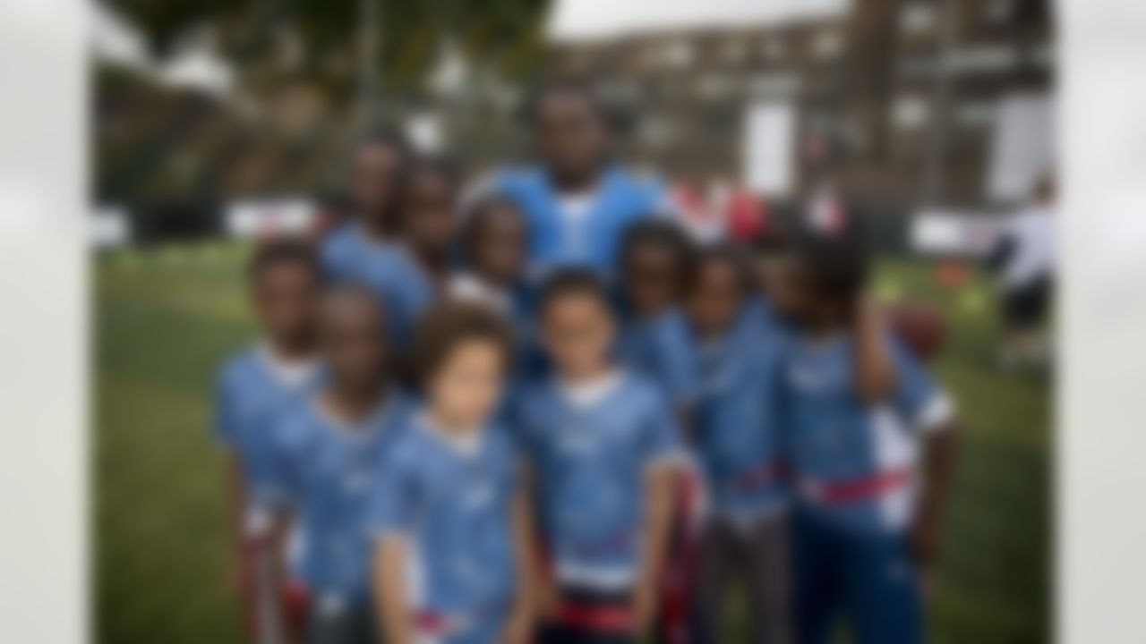 NFL team Detroit Lions' running back Joique Bell poses with a serious face he told the kids he coached to pull for a group photograph after they played in an NFL Summer Bowl tournament for kids from six London schools that have taken part in a football and education programme, at the Black Prince Community Hub in south London, Wednesday, July 15, 2015. The NFL will stage three international series regular-season games in autumn 2015 at Wembley Stadium in London. (AP Photo/Matt Dunham)