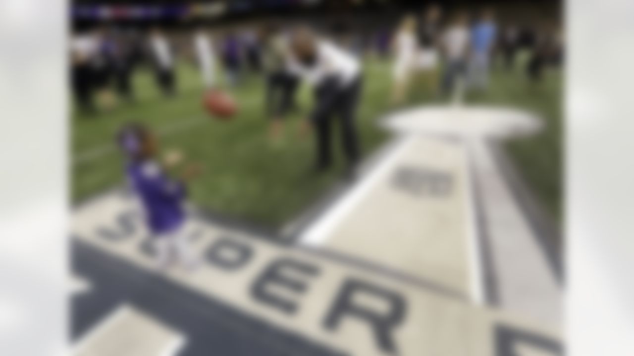 Baltimore Ravens fullback Vonta Leach (44) tosses a football to his daughter, Giselle, on the Mercedes-Benz Superdome field after an NFL Super Bowl XLVII walkthrough on Saturday, Feb. 2, 2013, in New Orleans. The Ravens face the San Francisco 49ers in Super Bowl XLVII on Sunday. (AP Photo/Patrick Semansky)