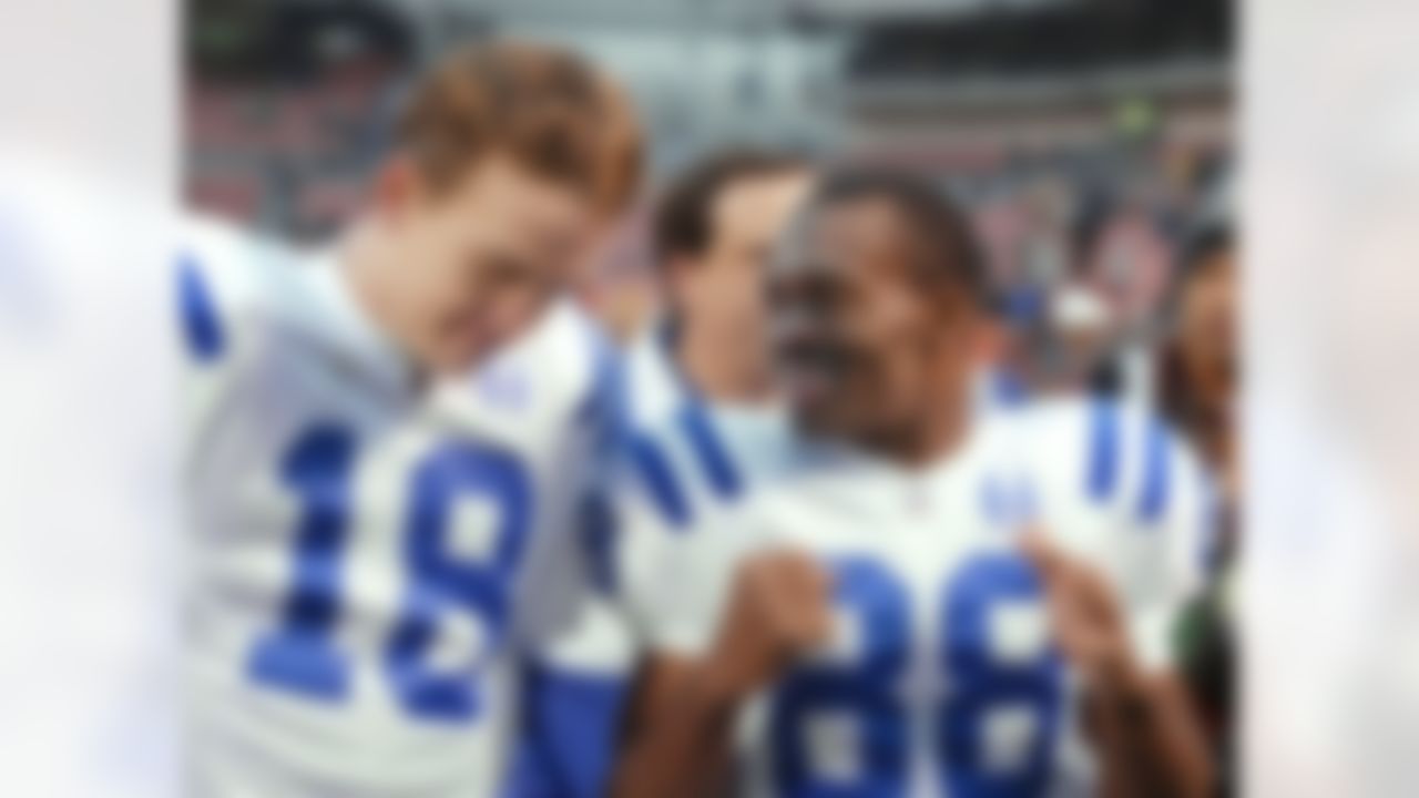 Indianapolis Colts receiver Marvin Harrison (88) talks to quarterback Peyton Manning (18) after the Colts' 28-23 win over the Cleveland Browns, Dec. 15, 2002, in Cleveland. Harrison and Manning are now the authors of the NFL's how-to manual on flawless play. (AP Photo/Ron Schwane)
