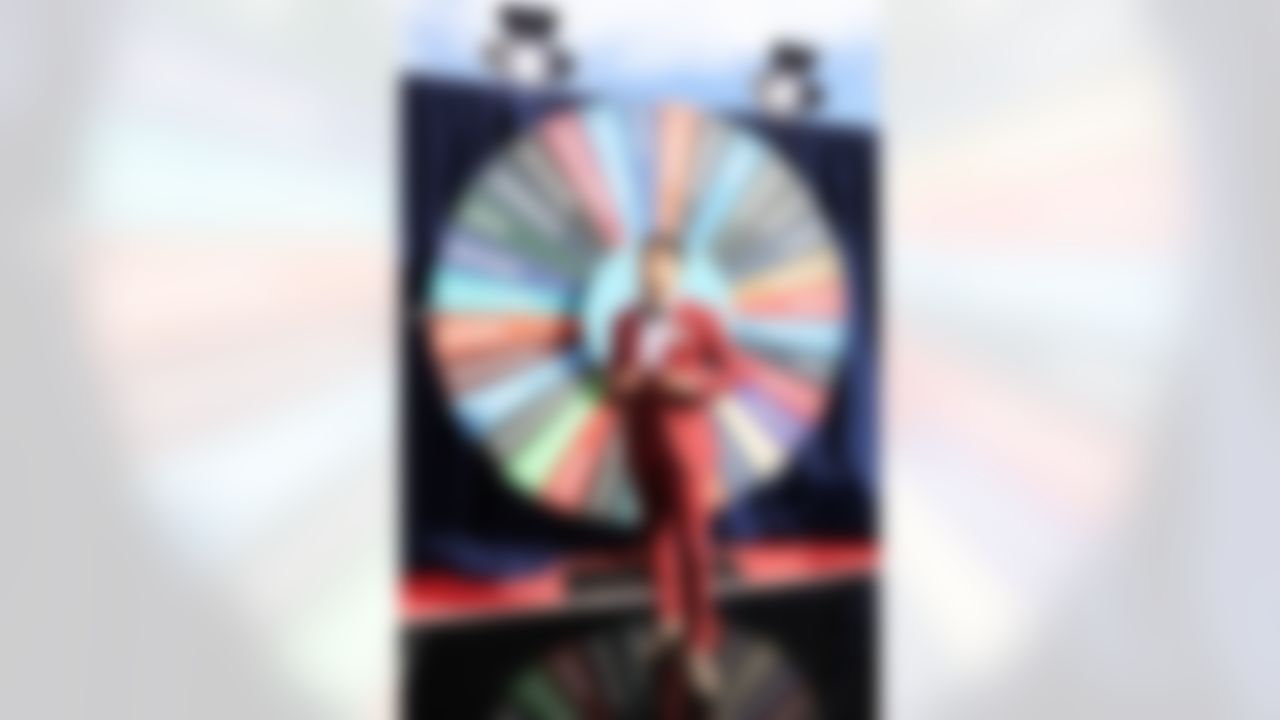 Louisville cornerback Jaire Alexander stands in front of a giant wheel with all 32 NFL teams.