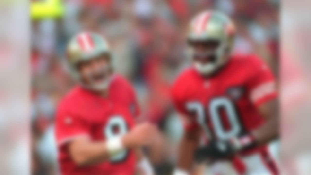 San Francisco 49ers quarterback Steve Young, left, smiles as he and 49ers wide receiver Jerry Rice rush to congratulate tight end Brent Jones after Jones scored the 49ers third touchdown against the Dallas Cowboys in San Francisco, Calif., in this Nov. 13, 1994 photo. Young is expected to announce his retirement from football at a news conference on Monday, June 12, 2000. (AP Photo/Susan Ragan)