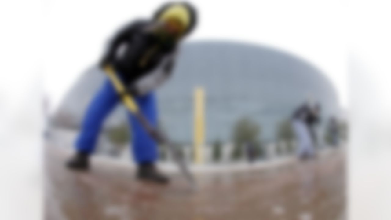 Yvette Hamby braves freezing temperatures as she works to clear a path into Cowboys Stadium for media day for NFL football Super Bowl XLV Tuesday, Feb. 1, 2011, in Arlington, Texas. (AP Photo/Charlie Riedel)