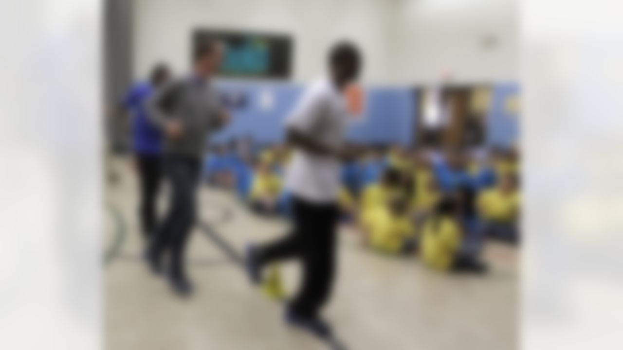 Miami Dolphins' Brandon Marshall, left, Indianapolis Colts' Peyton Manning, second left, and Atlanta Falcon's Roddy White run into greet a group of students at Frederick Douglass School 19 Friday, Feb. 3, 2012, in Indianapolis. The players participated in BOKS, that is school physical activity program backed by the Reebok Foundation(. AP Photo/Darron Cummings)