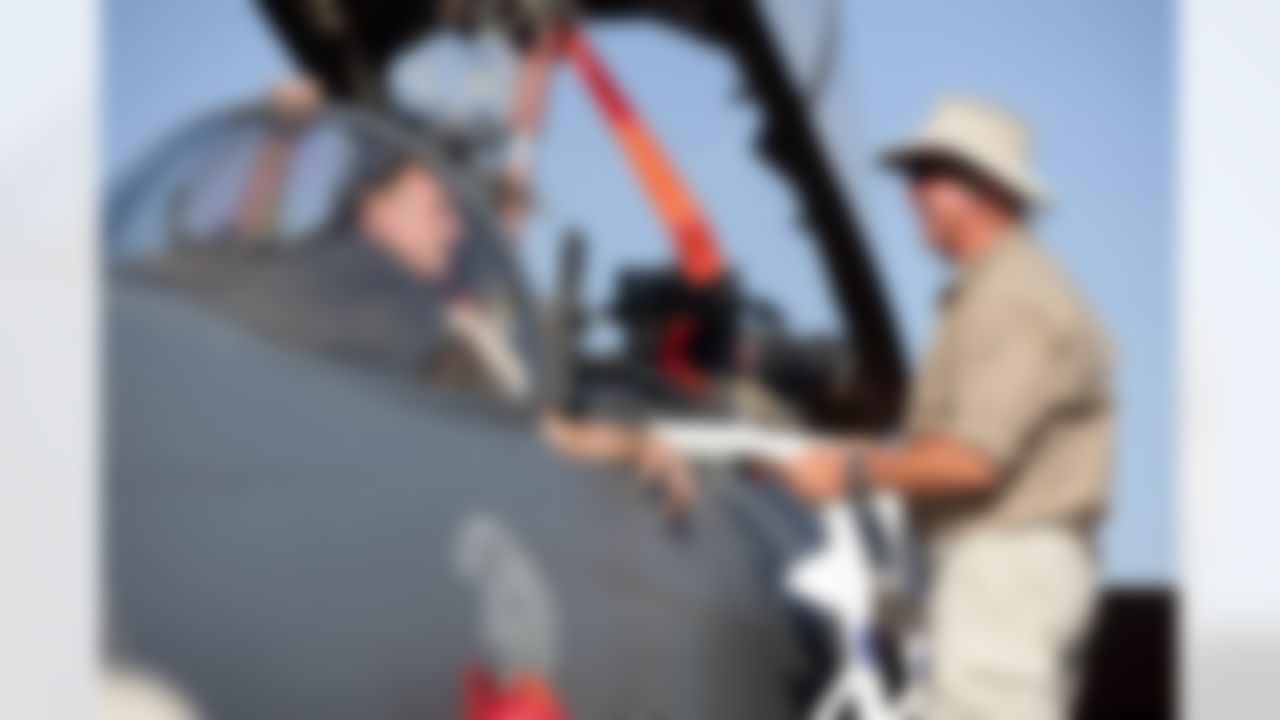 Carolina Panthers head coach John Fox gets a lesson from an crewman on the cockpit layout of the F-15 Strike Eagle during a stop on a USO/Armed Forces Entertainment tour of four top NFL coaches to Germany and the Persian Gulf on July 2, 2010. (Fred Greaves/USO)