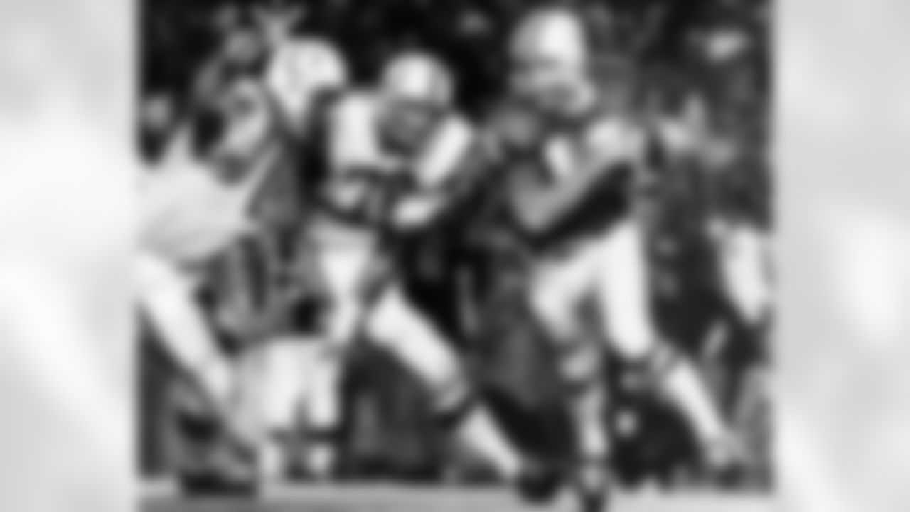 Dolphins' quarterback Bob Griese outruns a pair of Baltimore Colts tackles, Fred Miller (76) and Jim Bailey (79), Jan. 7, 1972, during Miami's 21-0 victory for their conference title and a Superbowl bid. (Associated Press)